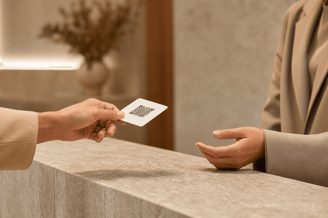 A clinic reception handoff — a QR card passed across a stone counter